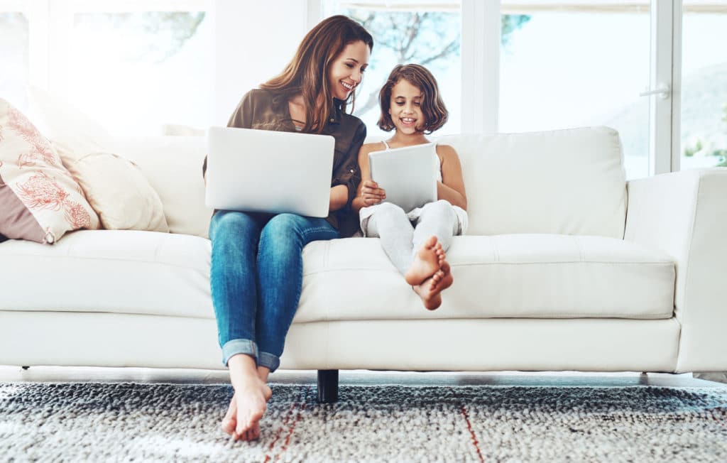 Mutter und Tochter mit Laptop und Tablet