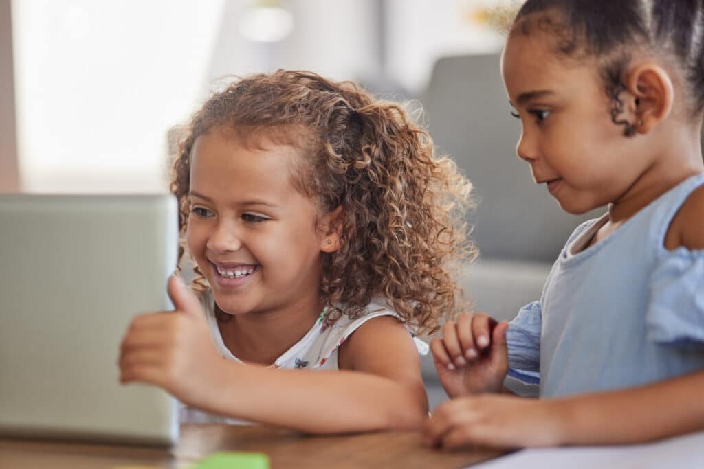 Staunende Kinder verwenden einen Laptop